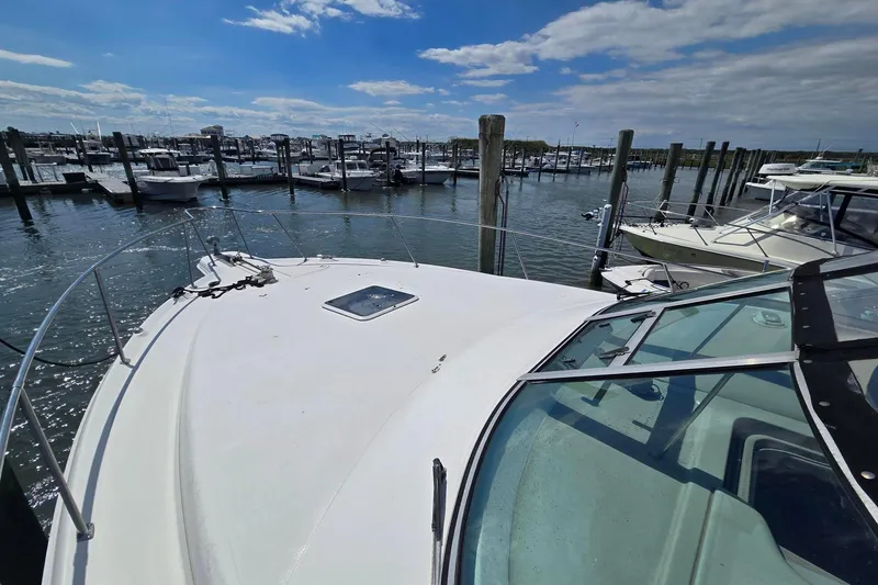 Slide: The Image of 1998 Sea Ray 330 Express docked at a marina under a partly cloudy sky. - 9