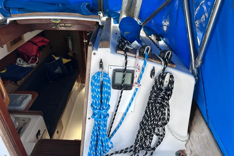 Slide: The Image of 1975 Cape Dory 28 sailboat interior with ropes, navigation equipment, and blue canopy. - 10