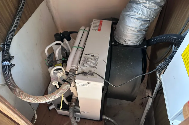 Slide: The Image of Air conditioning unit in a 1975 Cape Dory 28 boat, featuring various hoses and components. - 18