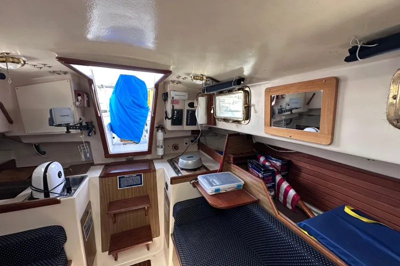 Slide: The Image of Interior of a 1975 Cape Dory 28 sailboat, featuring cozy seating and nautical equipment. - 26