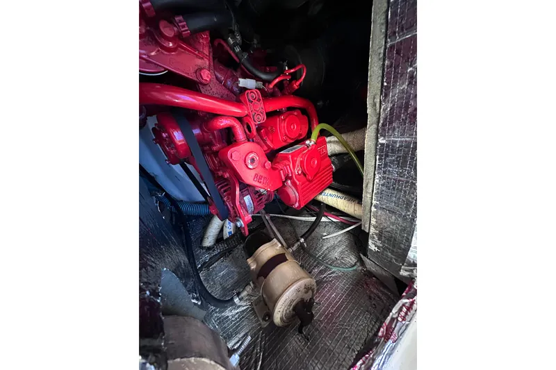Slide: The Image of Engine compartment of a 1975 Cape Dory 28 boat, featuring red mechanical components. - 28