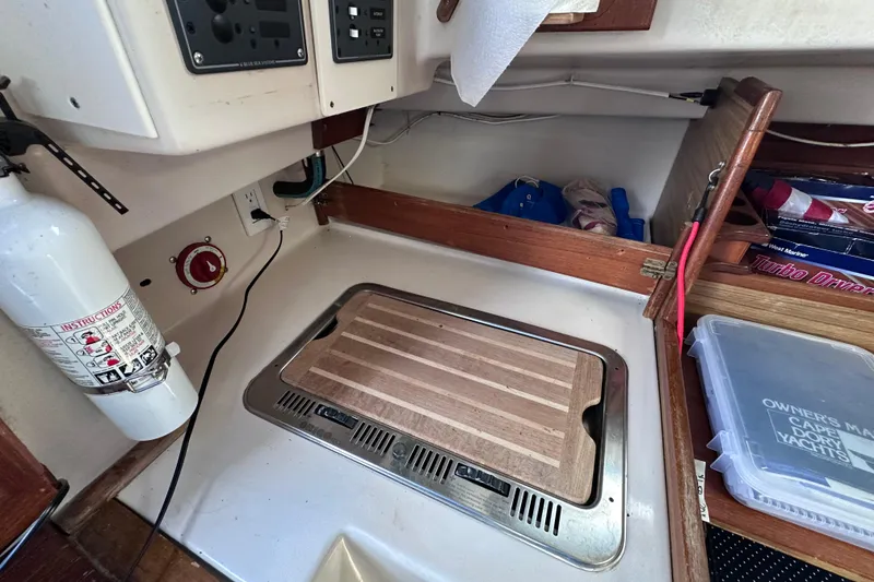 Slide: The Image of 1975 Cape Dory 28 interior with fire extinguisher, control panel, and storage compartments. - 30