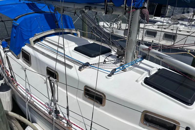 Slide: The Image of 1975 Cape Dory 28 sailboat with blue canopy docked at marina. - 4