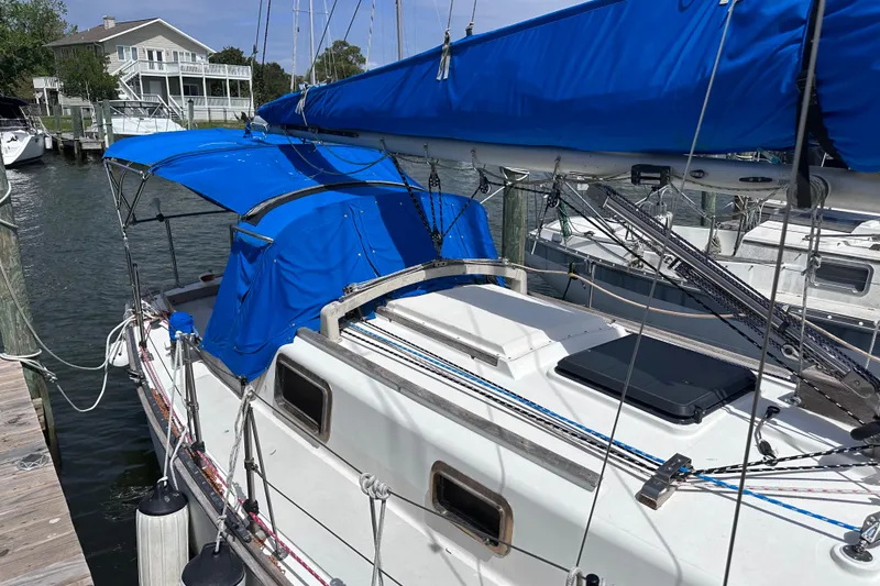 Slide: The Image of 1975 Cape Dory 28 sailboat docked, featuring blue canvas covers and classic design. - 5