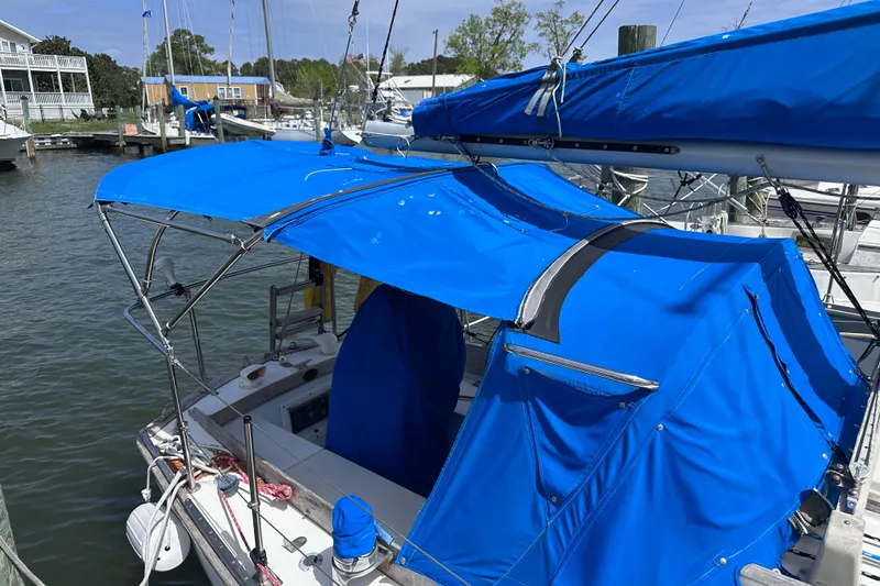 Slide: The Image of 1975 Cape Dory 28 sailboat with blue canvas cover docked at marina. - 6