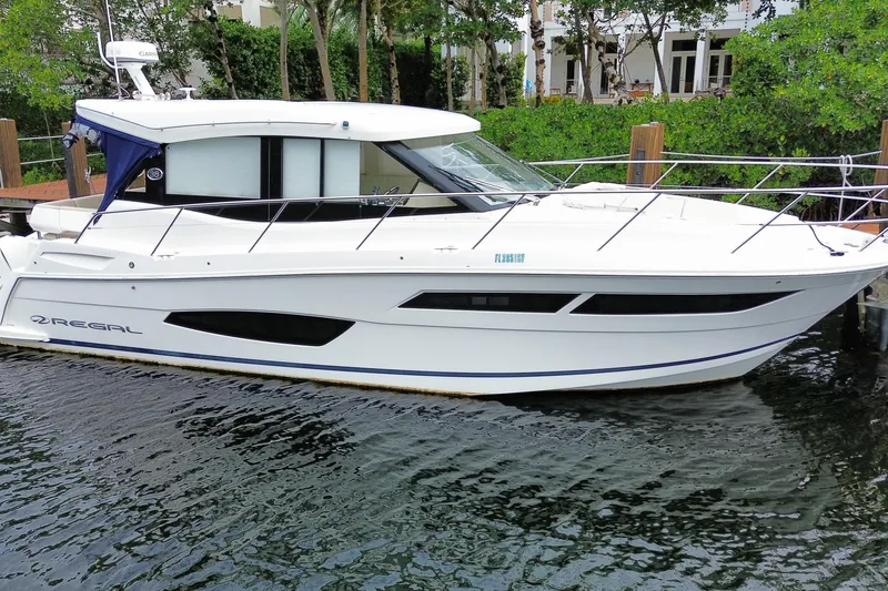 Slide: The Image of 2021 Regal 38 XO yacht docked, sleek white design, modern features, waterfront setting. - 12