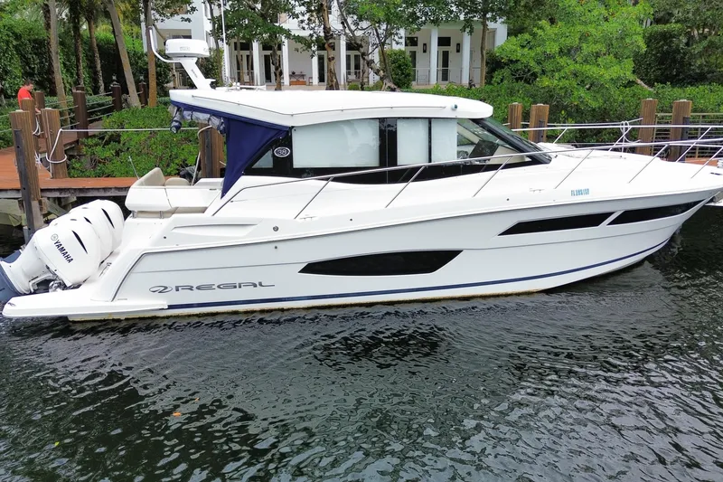 Slide: The Image of 2021 Regal 38 XO boat docked, featuring sleek design and Yamaha engines. - 13