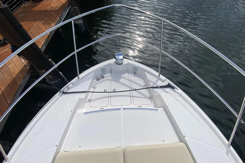 Slide: The Image of Bow view of 2021 Regal 38 XO yacht docked by wooden pier. - 16