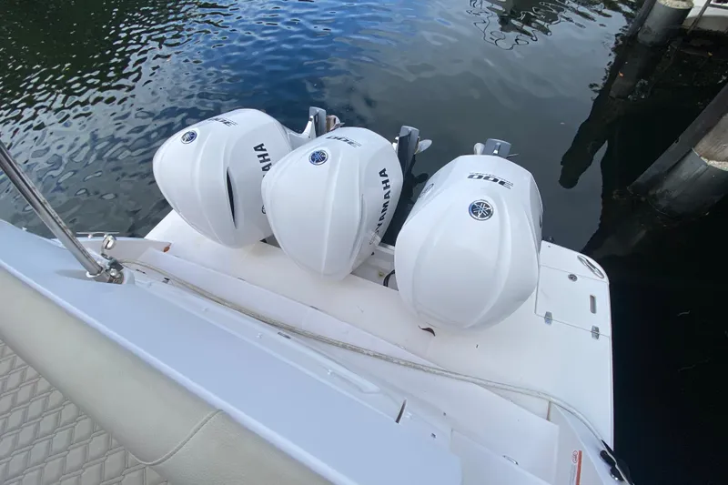 Slide: The Image of 2021 Regal 38 XO boat with triple Yamaha outboard engines docked by the water. - 24