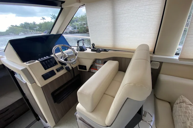 Slide: The Image of 2021 Regal 38 XO yacht helm with modern controls and plush seating. - 33
