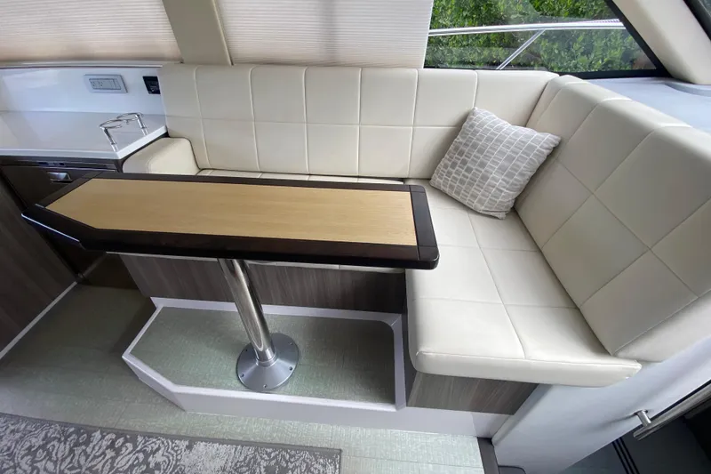 Slide: The Image of Luxurious interior seating area of 2021 Regal 38 XO yacht with elegant table and cushion. - 38