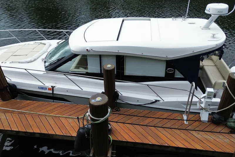 Slide: The Image of 2021 Regal 38 XO boat docked on wooden pier, side view. - 4