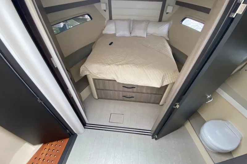 Slide: The Image of 2021 Regal 38 XO cabin interior with bed, storage drawers, and compact bathroom. - 40