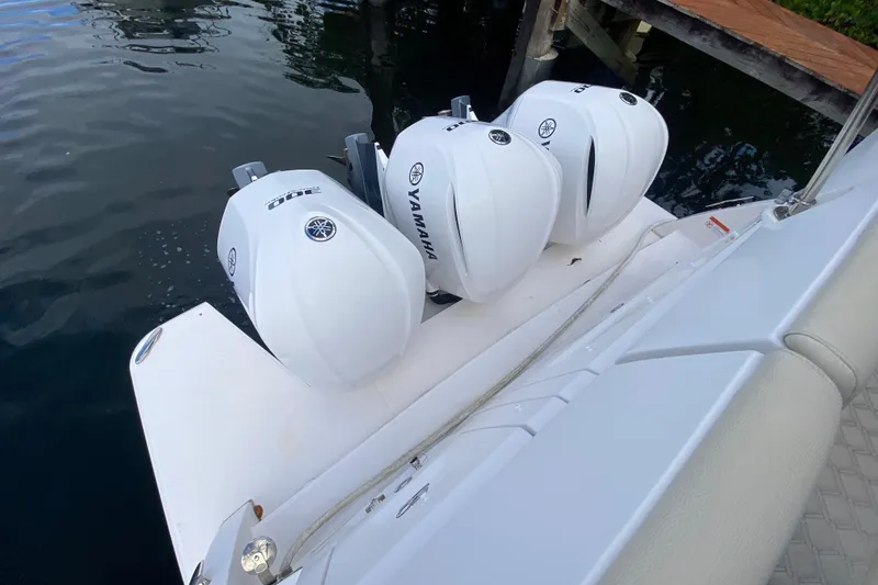 Slide: The Image of Triple Yamaha outboard engines on a 2021 Regal 38 XO boat docked by water. - 51