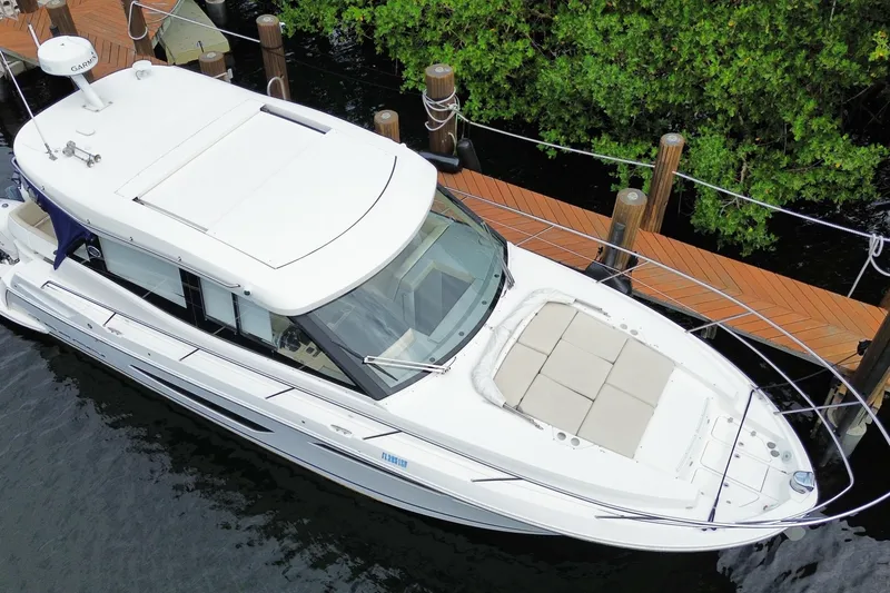 Slide: The Image of 2021 Regal 38 XO yacht docked, aerial view showcasing sleek design and spacious deck. - 6