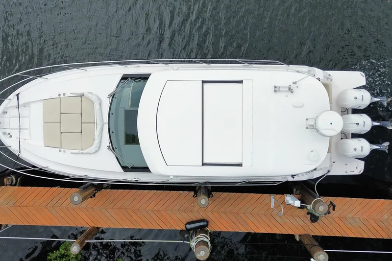 Slide: The Image of Overhead view of a 2021 Regal 38 XO yacht docked by a wooden pier. - 61