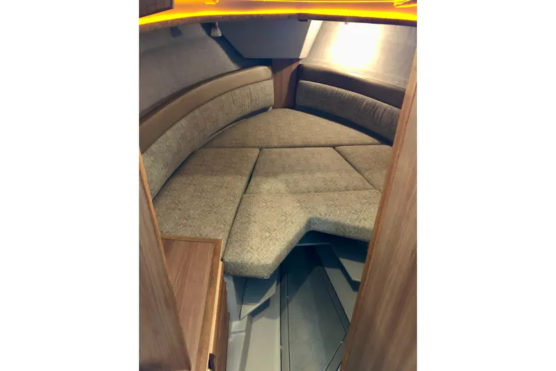 Slide: The Image of 2024 Ranger Tugs R-27 interior cabin with cozy seating and warm lighting. - 11