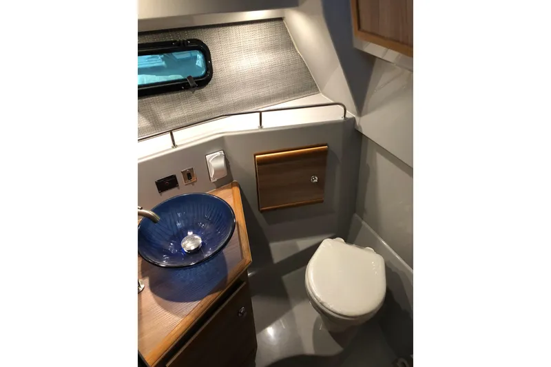 Slide: The Image of 2024 Ranger Tugs R-27 boat bathroom with modern sink and compact toilet. - 14