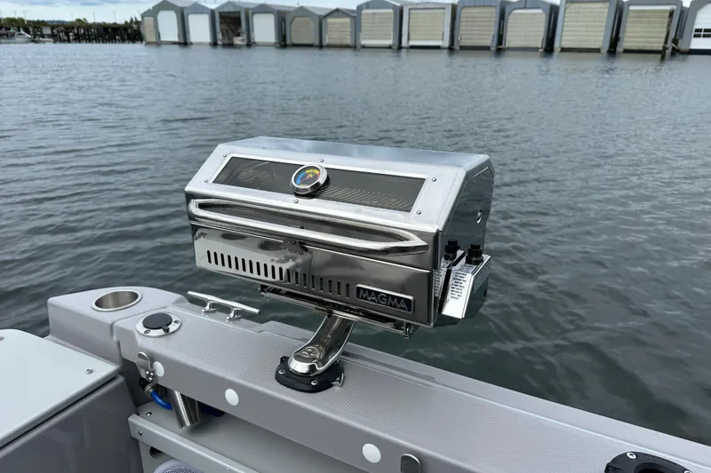 Slide: The Image of 2024 Ranger Tugs R-27 boat with Magma grill on deck, docked near waterfront. - 15