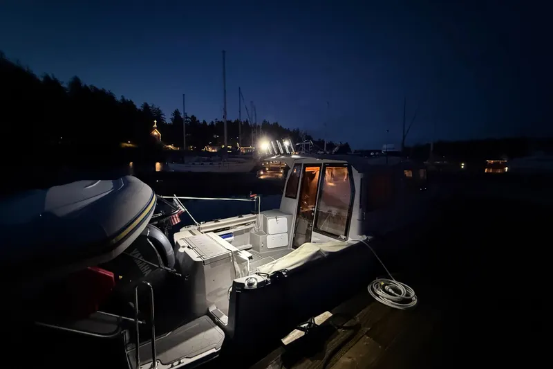 Slide: The Image of 2024 Ranger Tugs R-27 boat docked at night, illuminated by soft lighting. - 18