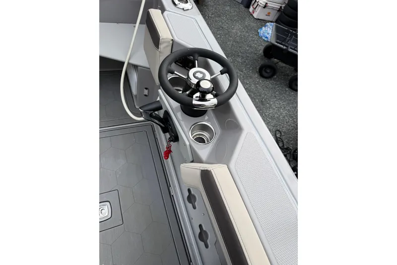 Slide: The Image of 2024 Ranger Tugs R-27 helm with steering wheel and cup holder. - 19