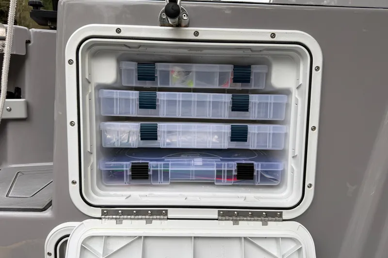Slide: The Image of Storage compartment with organized tackle boxes on a 2024 Ranger Tugs R-27 boat. - 22