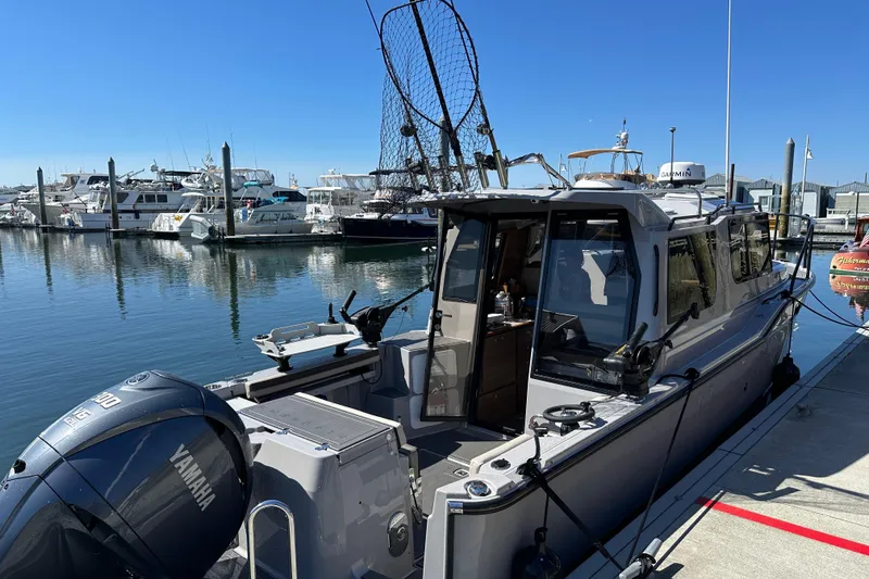 Slide: The Image of 2024 Ranger Tugs R-27 docked at marina with Yamaha outboard motor. - 4