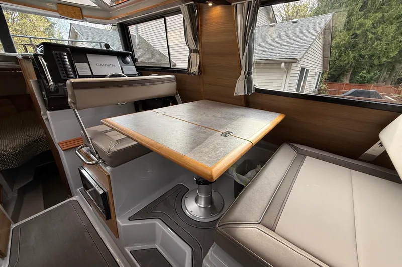 Slide: The Image of 2024 Ranger Tugs R-27 interior with dining table and navigation equipment. - 6