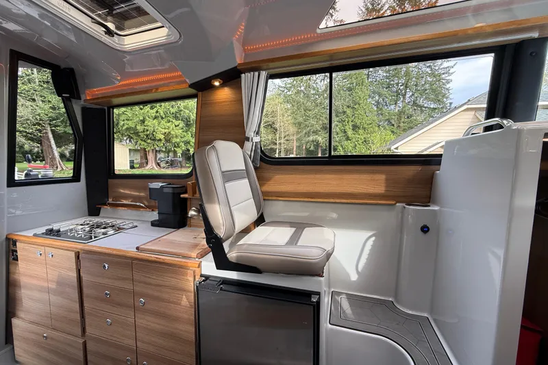 Slide: The Image of Interior of 2024 Ranger Tugs R-27 boat with modern kitchen and seating area. - 7