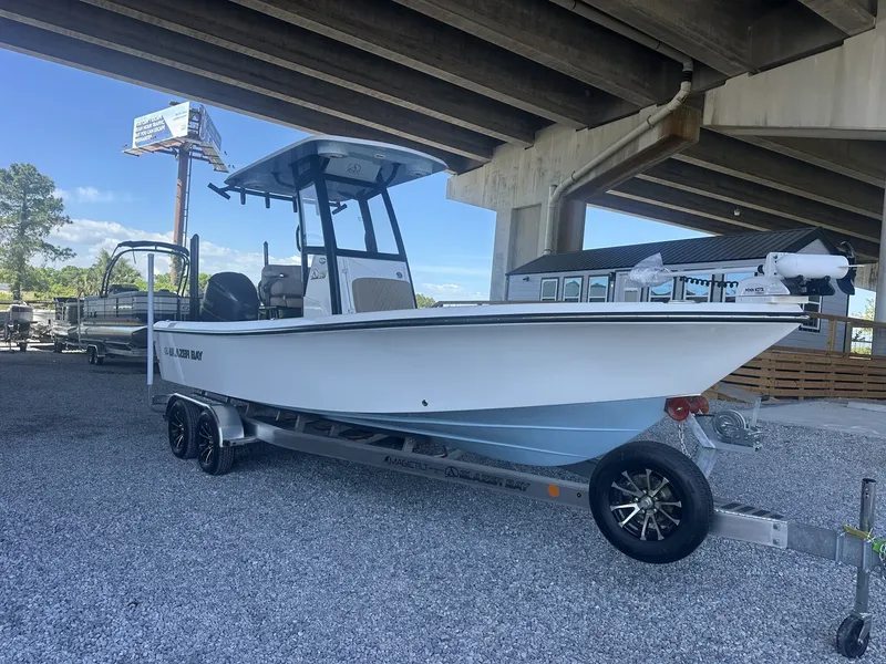 Slide: The Image of 2026 Blazer Bay 2440 boat on trailer under bridge. - 2
