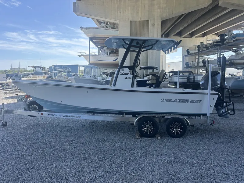 Slide: The Image of 2026 Blazer Bay 2440 boat on trailer under bridge. - 7