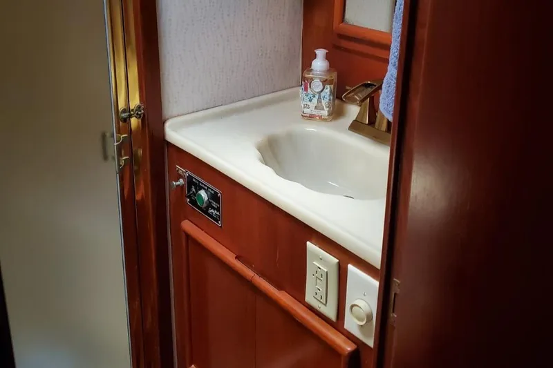 Slide: The Image of 1988 Post 46 Sportfish bathroom sink with wooden cabinetry and soap dispenser. - 47