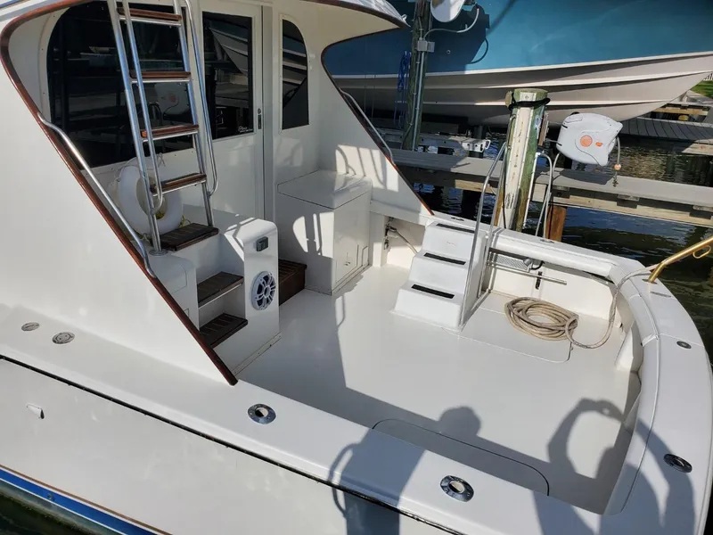Slide: The Image of 1988 Post 46 Sportfish boat deck with ladder and seating area, docked at marina. - 10