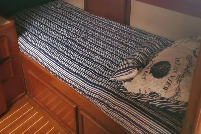 Slide: The Image of Cozy cabin bed in 1988 Post 46 Sportfish boat with striped bedding. - 46