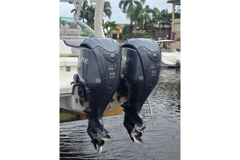 Slide: The Image of Twin Yamaha outboard engines on a 2023 Chaparral 300 OSX boat, docked near palm trees. - 11