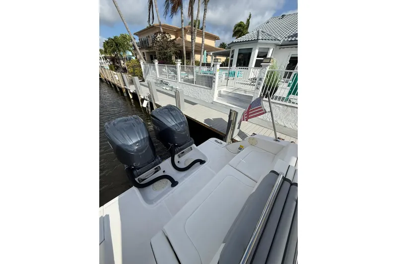 Slide: The Image of 2023 Chaparral 300 OSX boat docked with dual engines and American flag. - 13
