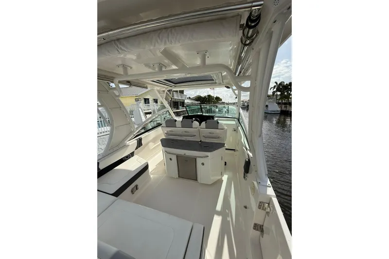 Slide: The Image of 2023 Chaparral 300 OSX boat interior with seating and helm, docked by the water. - 17