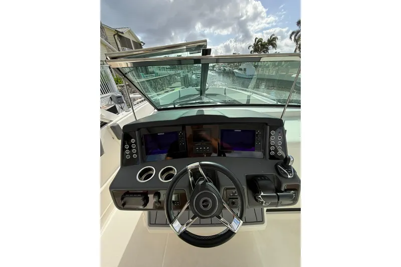 Slide: The Image of Cockpit view of 2023 Chaparral 300 OSX boat with modern controls and steering wheel. - 30