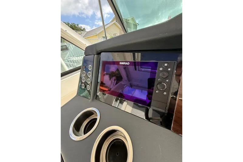 Slide: The Image of 2023 Chaparral 300 OSX dashboard with Simrad display and dual cup holders. - 33