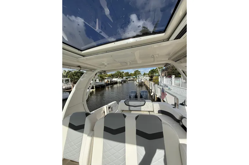 Slide: The Image of 2023 Chaparral 300 OSX boat interior with panoramic sunroof and canal view. - 36