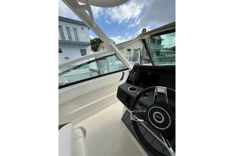Slide: The Image of 2023 Chaparral 300 OSX boat interior with modern dashboard and steering wheel. - 38
