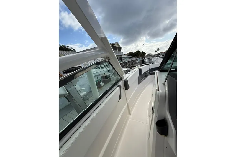 Slide: The Image of 2023 Chaparral 300 OSX boat deck view with sleek design and waterfront backdrop. - 39