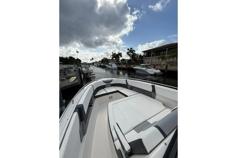 Slide: The Image of 2023 Chaparral 300 OSX boat docked in a scenic marina under cloudy skies. - 41