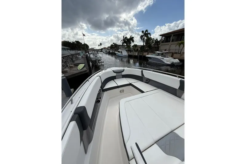 Slide: The Image of 2023 Chaparral 300 OSX boat docked in a marina under cloudy skies. - 42