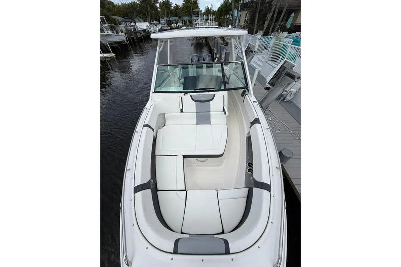 Slide: The Image of 2023 Chaparral 300 OSX boat with spacious seating, docked by a marina. - 45