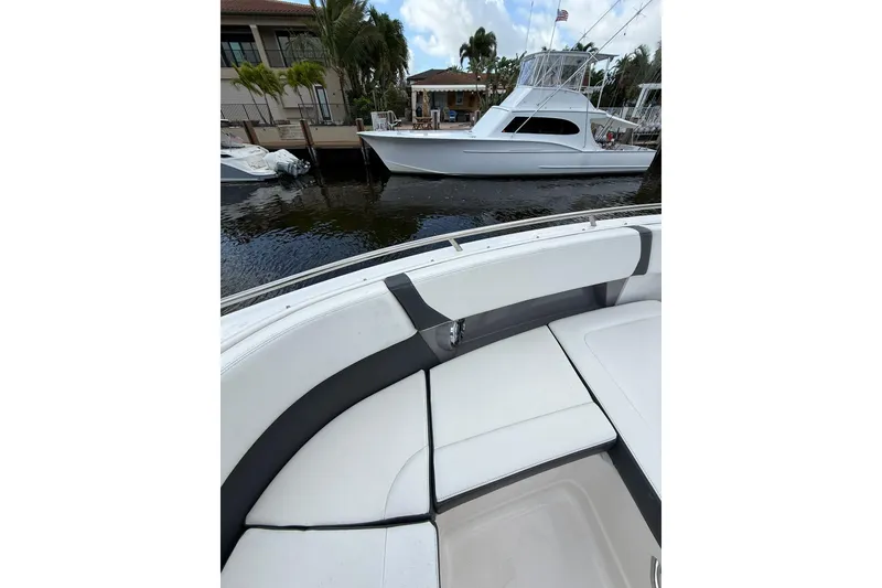 Slide: The Image of 2023 Chaparral 300 OSX boat interior with waterfront view and docked yacht. - 46