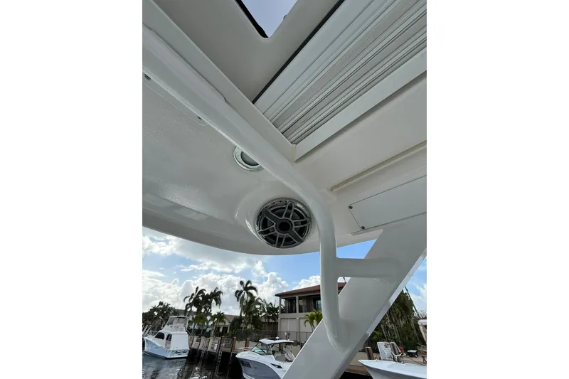 Slide: The Image of 2023 Chaparral 300 OSX boat speaker and canopy detail with marina background. - 50