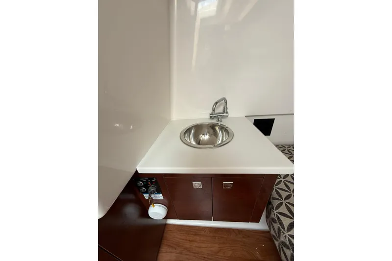 Slide: The Image of Compact sink area in 2023 Chaparral 300 OSX boat interior, featuring modern design elements. - 55