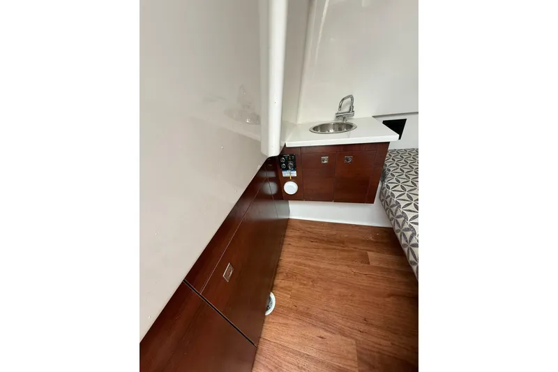 Slide: The Image of 2023 Chaparral 300 OSX interior with wood flooring, compact sink, and cabinetry. - 56