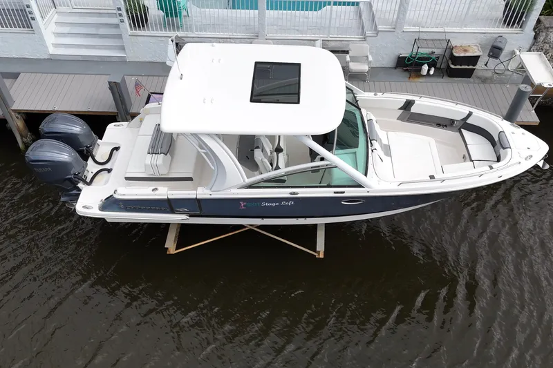 Slide: The Image of 2023 Chaparral 300 OSX boat docked, featuring dual outboard engines and spacious seating. - 7
